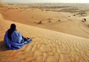Un homme assis dans les dunes